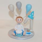 figurine anniversaire 1 an garçon, avec un gâteau d'anniversaire et des ballons