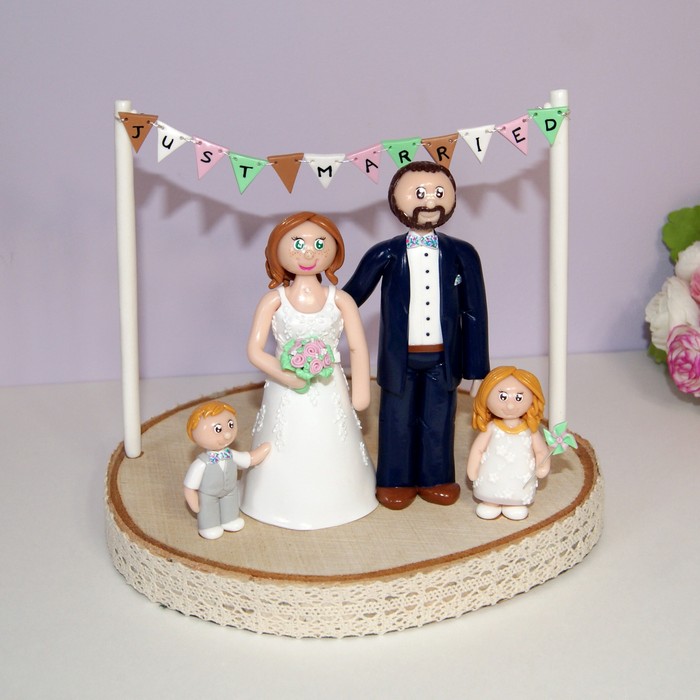figurine de mariage personnalisées, avec deux enfants, sur socle en bois brut, banderole de fanions
