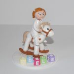 figurine enfant à califourchon sur un cheval à bascule, cubes lettres prénom