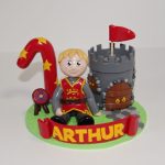 Figurine anniversaire 1 an Arthur, thème médiéval, avec enfant en tenue de chevalier et petit château