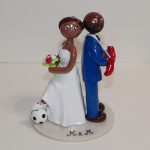 Mariée en robe blanche et ballon de foot, marié en costume avec gants de boxe