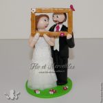 figurine de mariage tenant un cadre photo