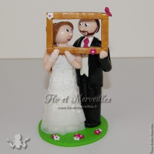 figurine de mariage tenant un cadre photo